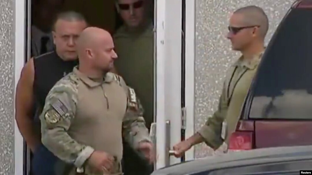 Cesar Altieri Sayoc (in dark shirt), who was arrested during an investigation into a series of parcel bombs, is escorted from an FBI facility in Miramar, Fla., Oct. 26, 2018, in this still image from video. 