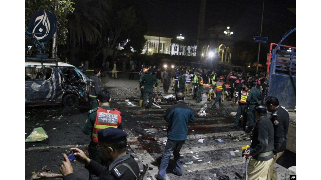 Police and security officers cordon off the area of a deadly bombing, in Lahore, Pakistan, Feb. 13, 2017.
