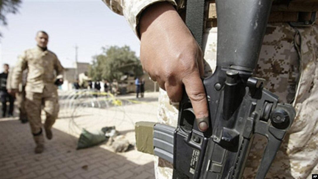 An Iraqi army soldier with an ink-stained index finger stands guard at the entrance to a polling station in central Baghdad, 04 Mar 2010