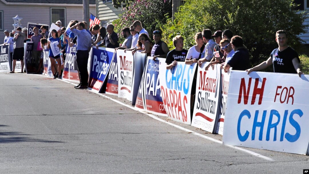 FILE - Democratic campaign supporters line the road leading to the New Hampshire Institute of Politics at St. Anselm College prior to a debate for New Hampshire's 1st Congressional District in Manchester, N.H., Sept. 5, 2018. 