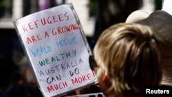 Protesters hold placards at a "Stand up for Refugees" rally held in central Sydney, Oct. 11, 2014.