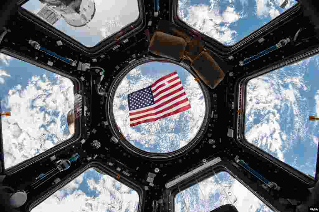An American flag is visible in the windows of the cupola aboard the International Space Station. Thanks to a bill passed by Texas legislators in 1997 that put in place technical voting procedure for astronauts – nearly all of whom live in Texas – they have the ability to vote from space through specially designed absentee ballots. To preserve the integrity of the secret vote, the ballot is encrypted and only accessible by the astronaut and the county clerk responsible for casting the ballot.