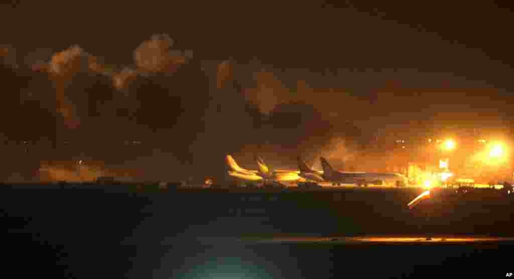 Fire illuminates the sky above the Jinnah International Airport in Karachi, Pakistan, June 8, 2014.