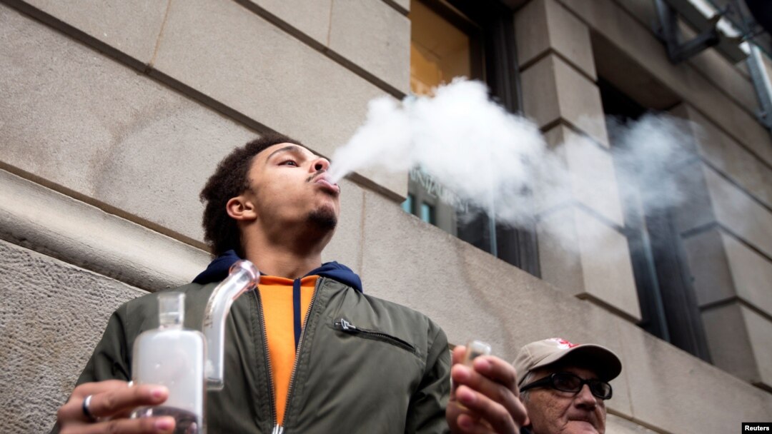 A man smokes as he waits in line for the opening of the Quebec Cannabis Society (SQDC) store, on the day Canada legalizes recreational marijuana, in Montreal, Quebec, Canada, Oct. 17, 2018. 