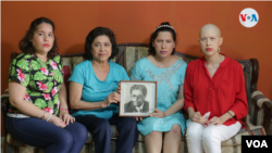La familia de Víctor Hugo Tinoco sostiene un retrato del exvicecanciller nicaragüense, arrestado por el gobierno de Daniel Ortega el 13 de junio de 2021. Foto Houston Castillo, VOA.