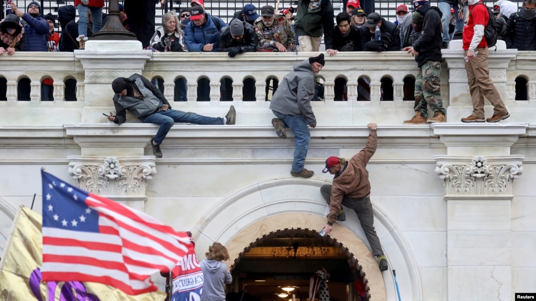 FILE - Supporters of U.S. President Donald Trump fight with members of law enforcement at a door they broke open as they storm the U.S. Capitol Building in Washington, Jan. 6, 2021.
