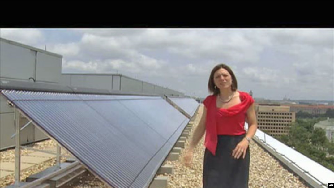 Meghan Chapple-Brown, director of Sustainability, stands by some of the solar hot-water systems that are on the rooftops of several buildings at George Washington University in urban Washington, D.C., June 2011