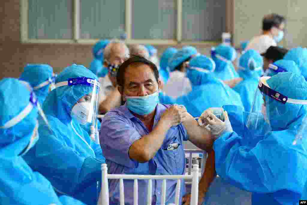 A man, center, receives the AstraZeneca Covid-19 coronavirus vaccine in Hanoi, Vietnam.