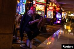 Una partidaria del candidato presidencial republicano Donald Trump mira su teléfono junto a las máquinas tragamonedas en Treasure Island Resort & Casino después de asistir a una fiesta nocturna del caucus de Nevada en las Vegas, Nevada, EEUU, el 8 de febrero de 2024.