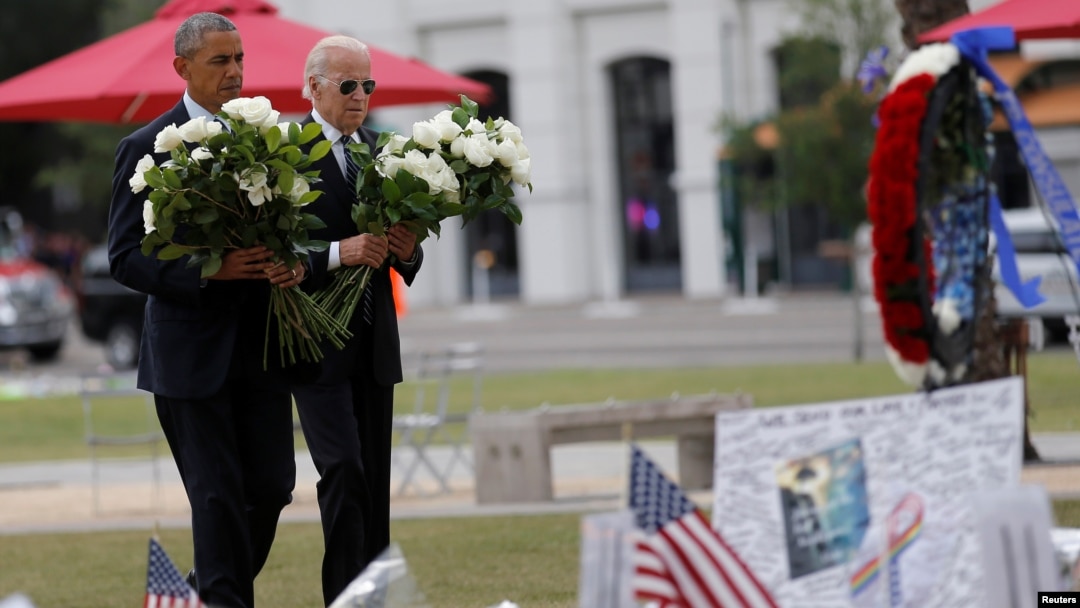 President Barack Obama, left, and Vice President Joe Biden place flowers at a makeshift memorial for shooting victims of the massacre at a gay nightclub in Orlando, Fla., June 16, 2016. 