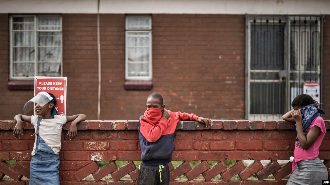 Children keep safe distancing as they line up at a food distribution organized by the grassroots charity Hunger Has No Religion, in Westbury, Johannesburg, South Africa, on May 19, 2020. 
