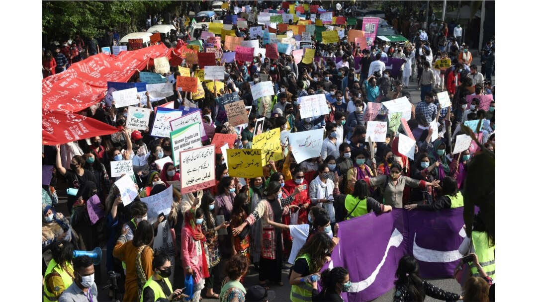 FILE - Activists of the Aurat March carry placards as they march during a rally to mark International Women's Day in Lahore, March 8, 2021.