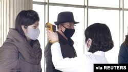 지난 4일 평양에서 신종 코로나바이러스 방역을 위해 시민들의 체온을 재고 있다.