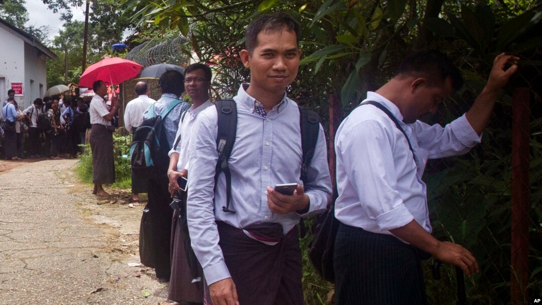 Swe Win, second right, an editor of the nonprofit online news outlet Myanmar Now, waits with other journalists for trial of The Voice editor Kyaw Min Swe outside a township court in Yangon, Myanmar, June 23, 2017.