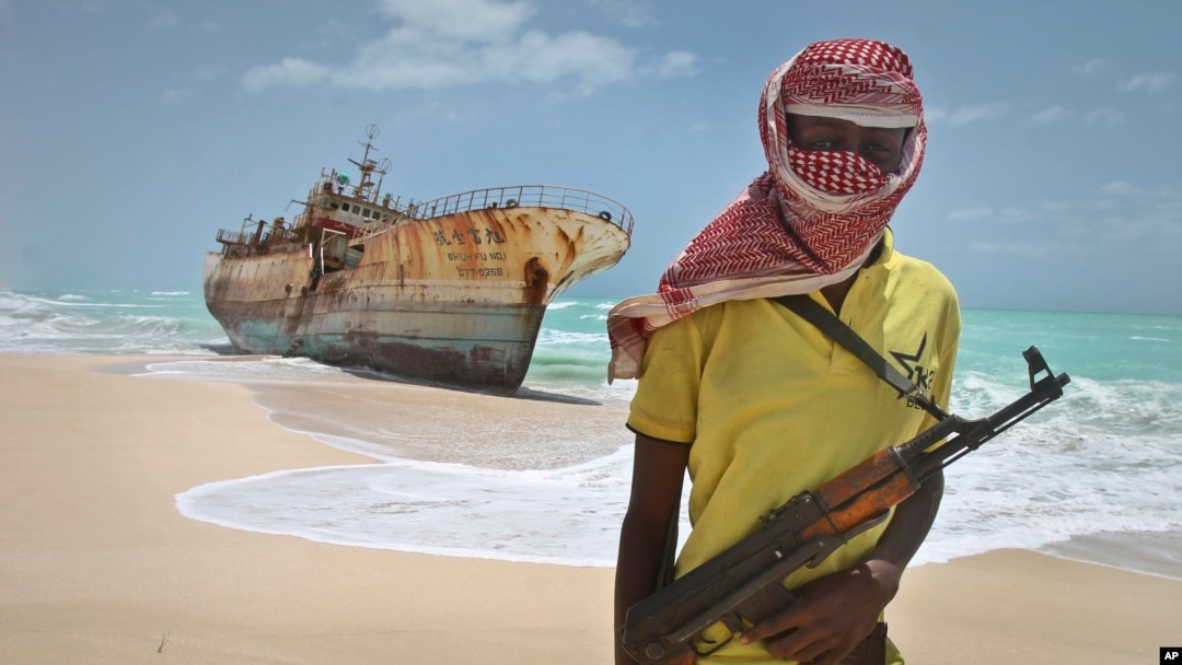 FILE - In this 2012 photo, a Somali pirate stands near a Taiwanese fishing vessel washed ashore after the pirates were paid a ransom and the crew were released.