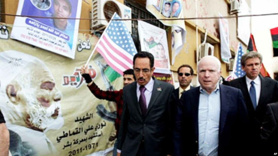 US Republican senator John McCain (R) walks with Abdul Hafiz Ghoqa, spokesman of the Libyan National Transitional Council (NTC), during his tour to the rebel headquarters in their eastern stronghold city of Benghazi , April 22, 2011