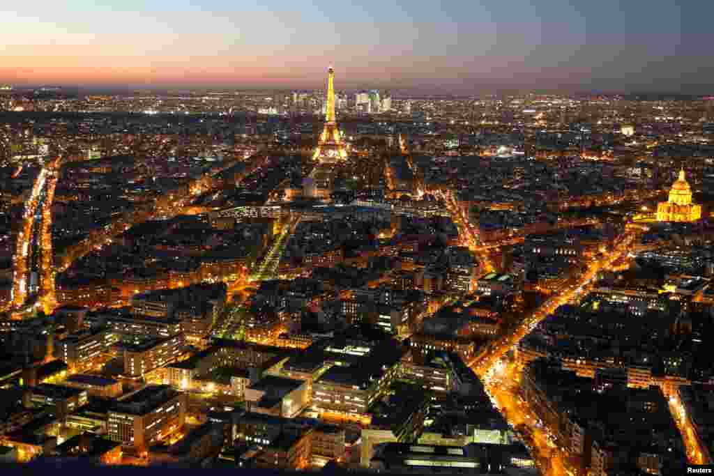 A general view shows the illuminated Eiffel Tower (C), the Hotel des Invalides (R) and rooftops at night in Paris, France, Nov. 28, 2016.