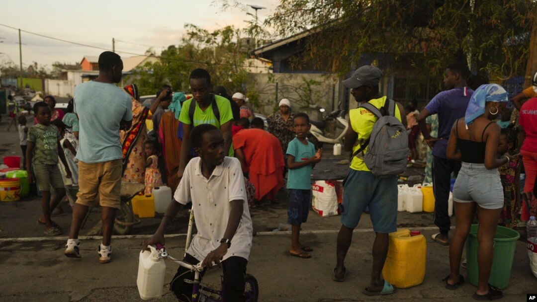 La gente hace fila para recolectar agua el miércoles 18 de diciembre de 2024 en la isla francesa de Mayotte, en el océano Índico.