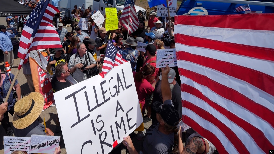 FILE - Demonstrators confront each other, Friday, July 4, 2014, outside a U.S. Border Patrol station in Murrieta, Calif. Demonstrators on both sides of the immigration debate had gathered where the agency was foiled earlier this week in an attempt to bus in and process some of the immigrants who have flooded the Texas border with Mexico. (AP Photo/Mark J. Terrill)