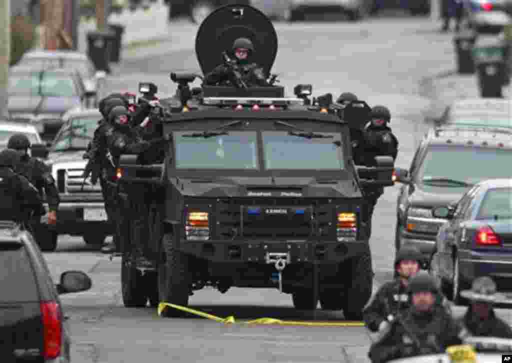 Police patrol through a neighborhood in Watertown, while searching for a suspect in the Boston Marathon bombings, April 19, 2013.