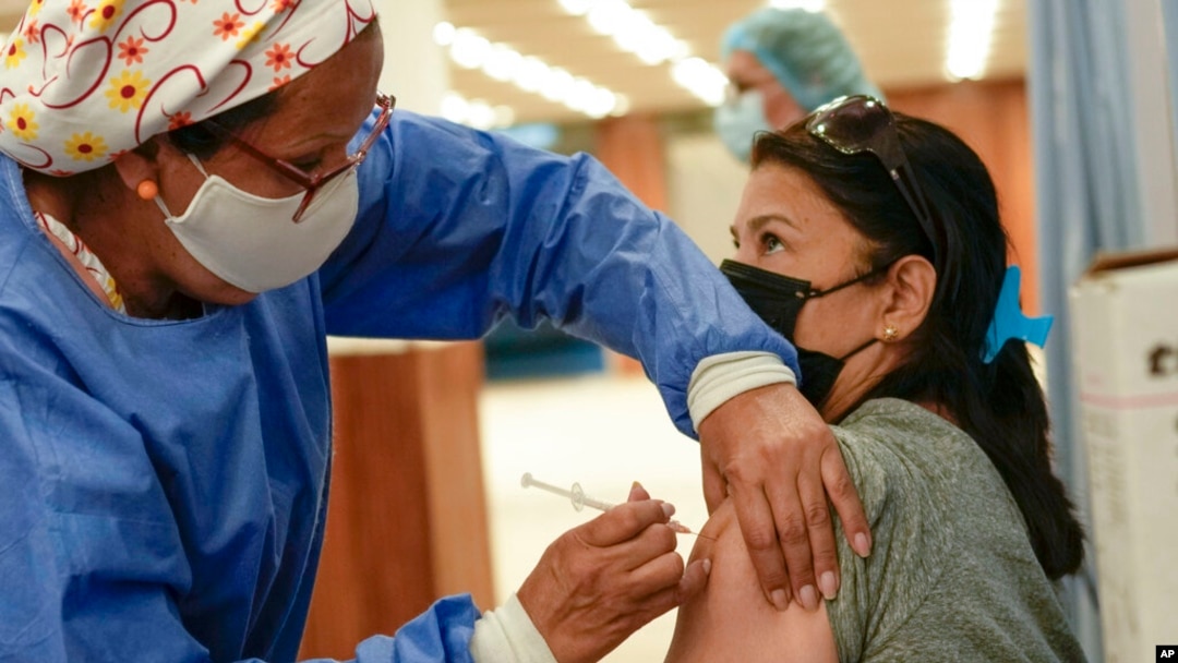 Una mujer venezolana recibe una tercera dosis de la vacuna Sinopharm contra el COVID-19 en Caracas el 3 de enero de 2022.