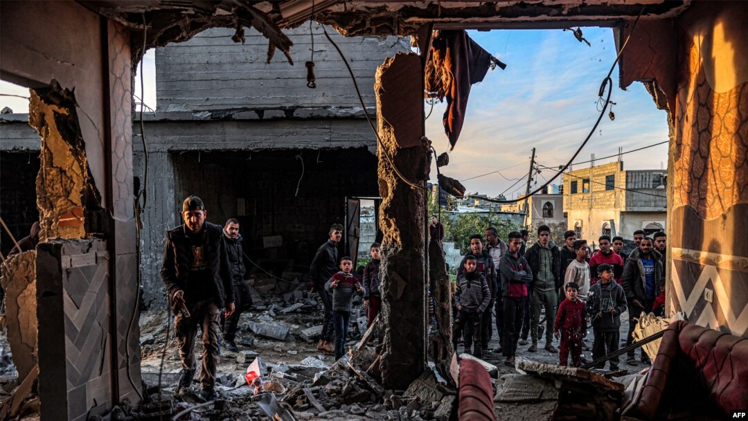 Un grupo de personas inspeccionan los escombros en un edificio dañado por un bombardeo israelí en Rafah, en el sur de la Franja de Gaza, el 11 de febrero de 2024.