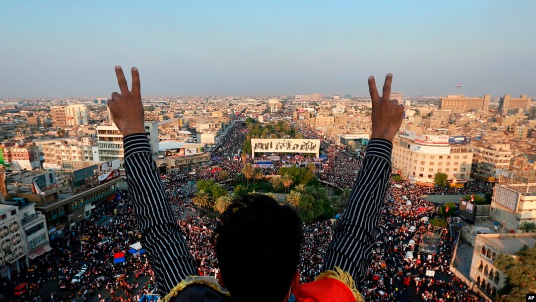 A protester flashes the victory sign while anti-government protesters gather in Tahrir Square during ongoing protests in Baghdad, Iraq, Oct. 31, 2019. 