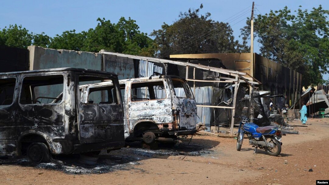 FILE - Burnt vehicles and houses are pictured on a street, after Boko Haram militants raided the town of Benisheik, west of Borno State capital Maiduguri.