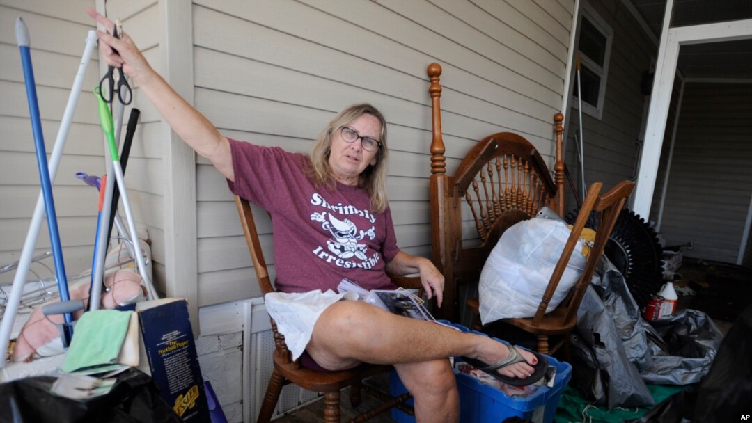 Brenda Palmer is surrounded by belongings from her mobile home, which filled with floodwaters from Hurricane Ian, in Fort Myers, Fla., on Oct. 9, 2022.