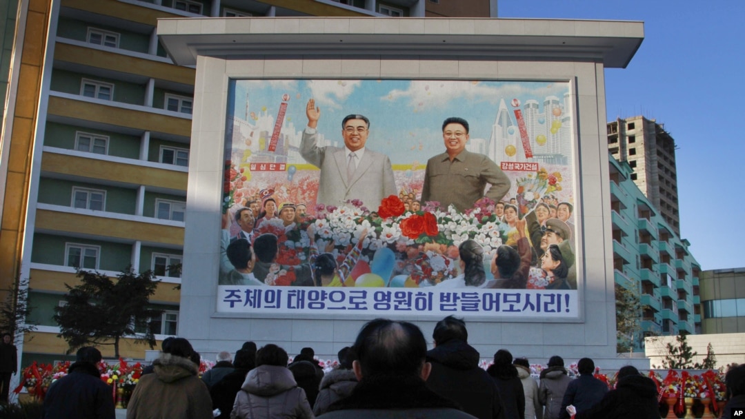 FILE - North Koreans gather in front of a portrait of their late leader Kim Il Sung, left, and Kim Jong Il, right, paying respects to their late leader Kim Jong Il, to mark the third anniversary of his death.