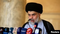 FILE - Iraqi Shi'ite cleric Muqtada al-Sadr delivers a sermon to worshippers during Eid al-Fitr prayers at the Kufa mosque near Najaf, June 5, 2019.