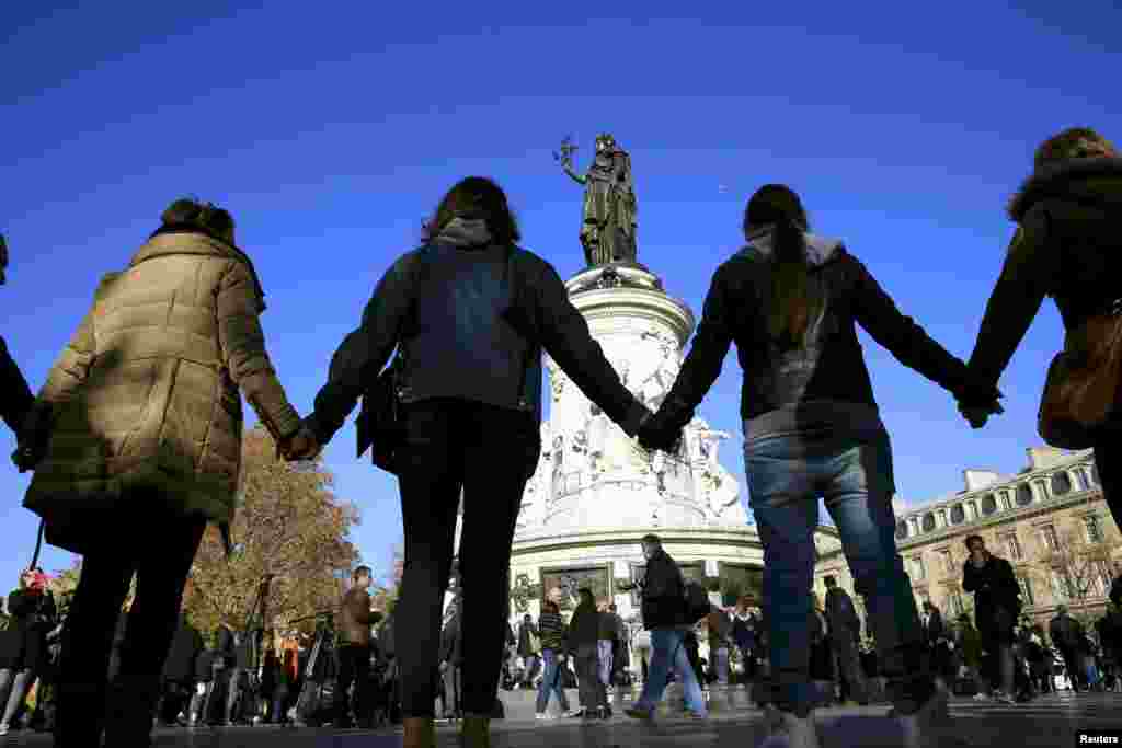 People hold hands to form a human solidarity chain near the site of the attack at the Bataclan concert hall in Paris, Nov. 15, 2015.