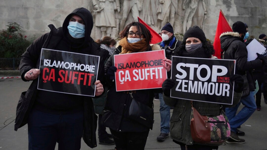 FILE - Activists hold placards reading 'Islamophobia is enough' and 'Stop Zemmour', Feb. 14, 2021, in Paris.