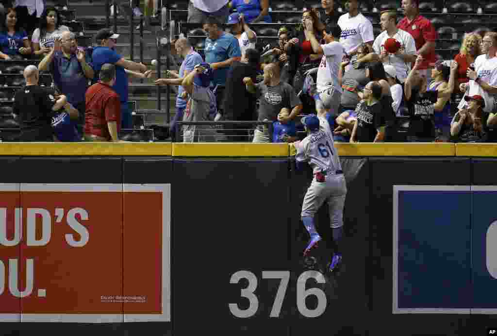 Los Angeles Dodgers left fielder Alex Verdugo (61) jumps in vain for home run hit by Arizona Diamondbacks' A.J. Pollock during the ninth inning of a baseball game, Sept. 24, 2018, in Phoenix, Arizona.