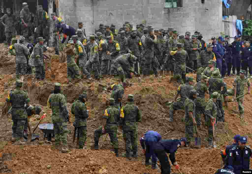 Soldiers search for survivors after a bus and two nearby houses were buried by a mountain landslide in Altotonga in Veracruz state, along Mexico's Gulf coast, Sept. 16, 2013.