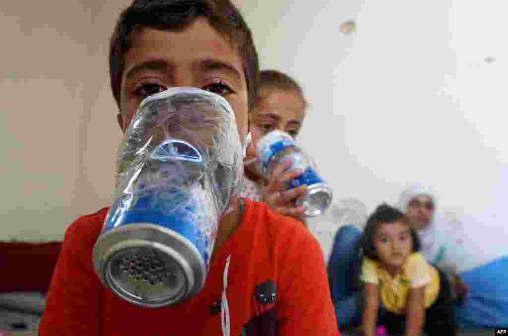 Children try improvised gas masks in their home in Binnish in Syria's rebel-held northern Idlib province as part of preparations for any upcoming raids.