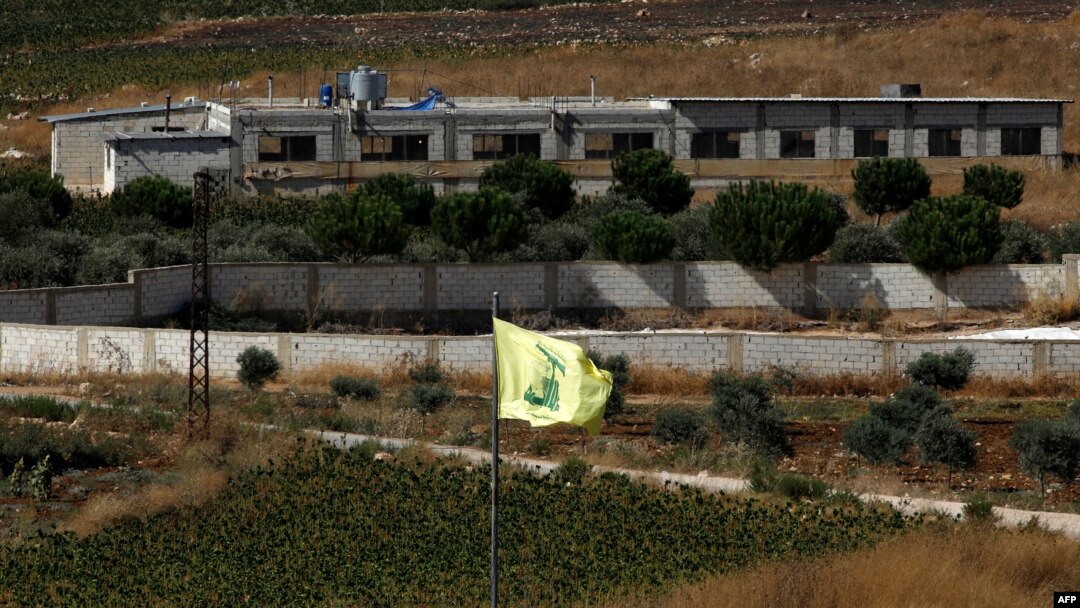A Hezbollah flag flies in the Lebanon village of Aitaroun, near the northern Israeli town of Avivim, Aug. 26, 2019. 