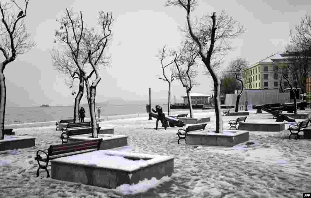 People walk on a snow covered square in Istanbul,Turkey, as heavy snowfall over the city disrupts air traffic and land transports.