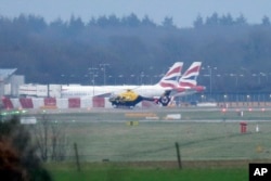 A police helicopter flies over Gatwick Airport as the airport remains closed after drones were spotted over the airfield last night and this morning, in Gatwick, England, Dec. 20, 2018.