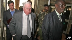 FILE - Jerome Corsi, center, who wrote "The Obama Nation: Leftist Politics and the Cult of Personality," follows an immigration department officer holding his passport in Nairobi, Kenya, Oct. 7, 2008.