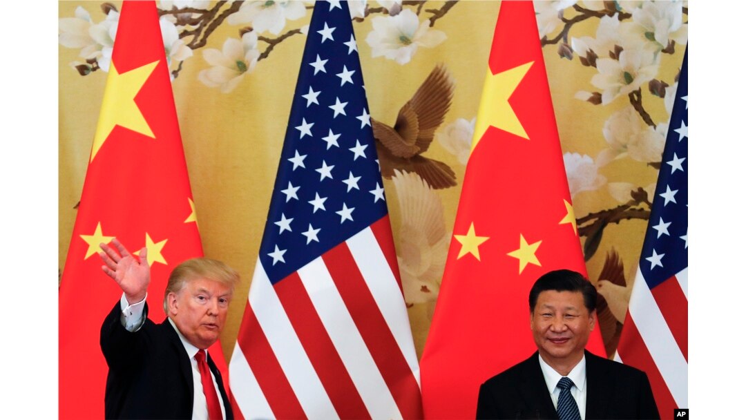 FILE - U.S. President Donald Trump waves next to Chinese President Xi Jinping after attending a joint press conference at the Great Hall of the People in Beijing.