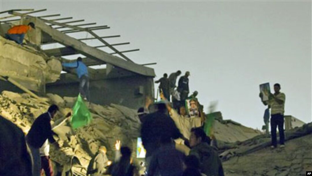 Moammar Gadhafi supporters inspect damage following an airstrike in Tripoli, Libya. The airstrike on Gadhafi's sprawling residential compound early Monday badly damaged two buildings, including a structure where Gadhafi often held meetings, guards at the 