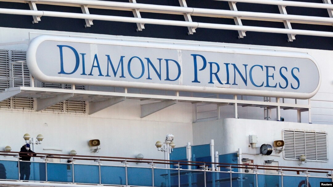 FILE PHOTO: A passenger wearing a mask stands on the deck of the cruise ship Diamond Princess, as the vessel's passengers continue to be tested for coronavirus, at Daikoku Pier Cruise Terminal in Yokohama, south of Tokyo, Japan February 13, 2020.