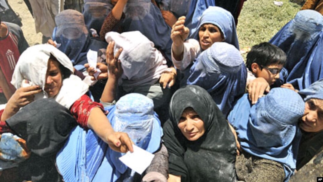 Afghan women stretch for food donations from the World Food Programme (WFP) in Kabul, (File)
