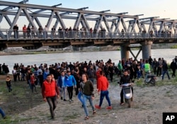 People and relatives of victims waiting on the bank of the Tigris river where the ferry sank in Mosul, Iraq, Thursday, March 21, 2019.