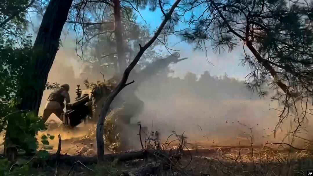 En esta foto, tomada de un video publicado el viernes 12 de julio de 2024 por el Ministerio de Defensa de Rusia, soldados rusos disparan un obús desde su posición contra tropas ucranianas en un lugar no revelado de Ucrania. 
