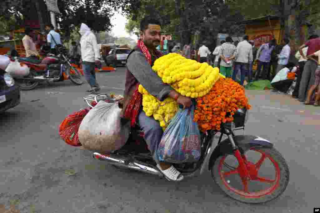 A man transports marigold flower garlands on a motorbike during the Diwali festival in Allahabad, India, Nov. 3, 2013.