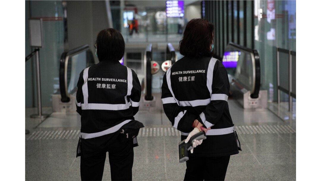 A health surveillance officer with temperature scanner waits for passengers at the Hong Kong International Airport, Jan. 4, 2020. Hong Kong authorities activated a new response protocol Saturday as fears spread about a mysterious infectious disease.