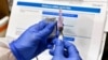 FILE - A nurse prepares a shot as the world's biggest study of a possible COVID-19 vaccine, developed by the National Institutes of Health and Moderna Inc., gets under way in Binghamton, N.Y., July 27, 2020.