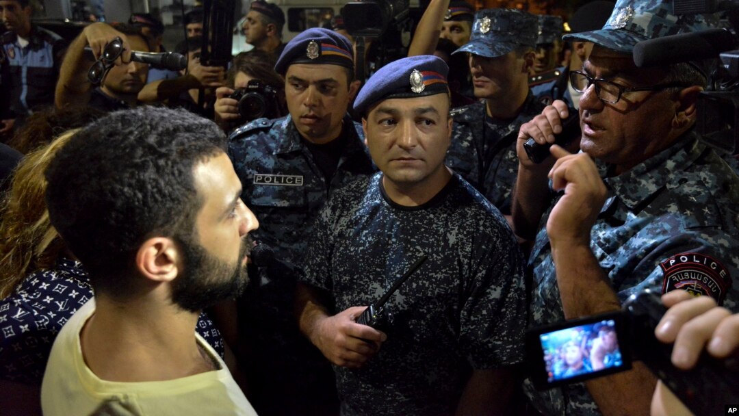 Protesters speak to police officers during a night rally to support the radical opposition group gunmen in the Republican Square in Yerevan, Armenia on July 31, 2016. 